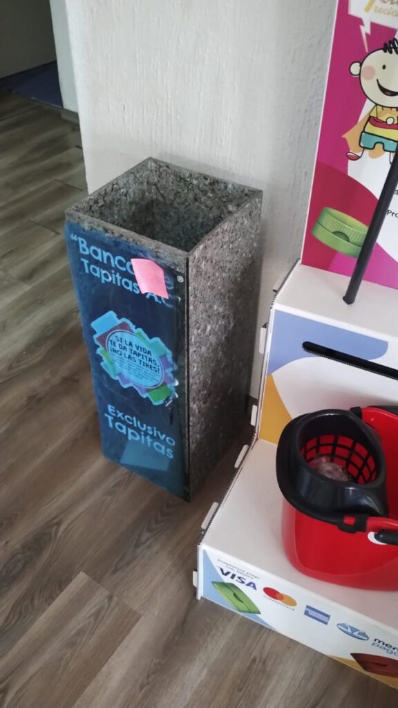 Contenedor de tapitas en banco de tapitas realizado con plástico reciclado